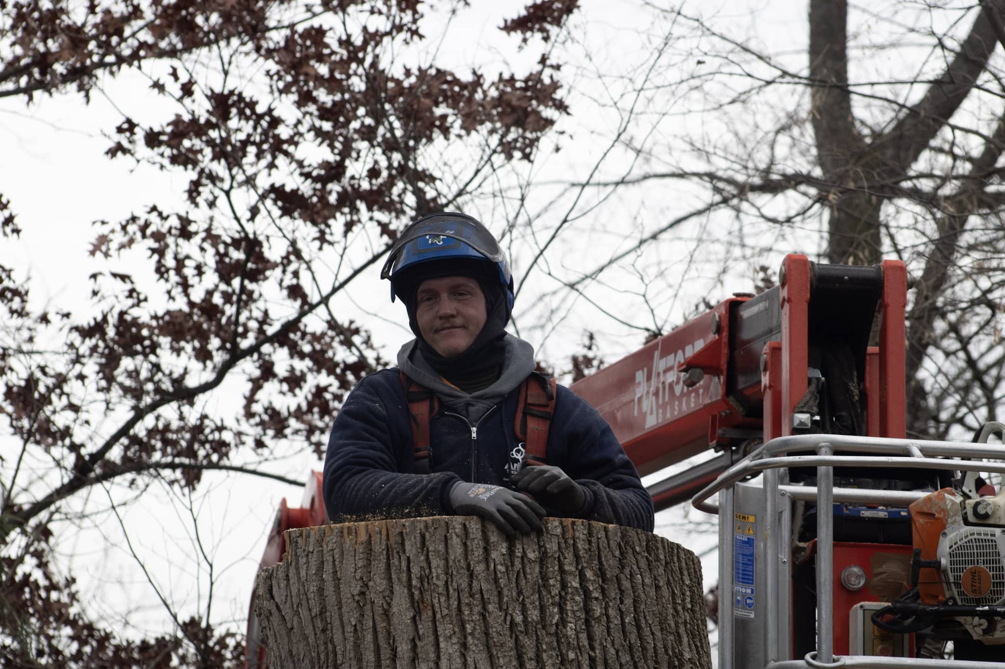 worker leaning on a trump stump with a crane in the background